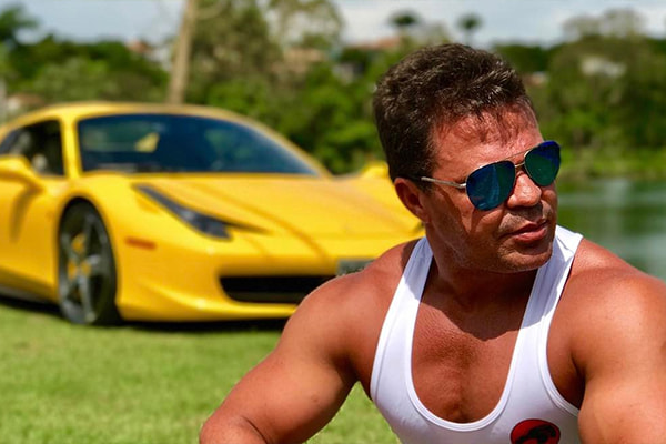 Eduardo Costa posa para foto no Instagram com carro luxuoso desfocado ao fundo