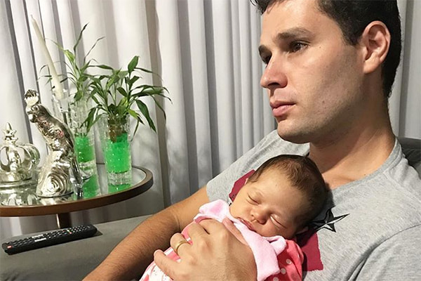 Pedro Leonardo posa com a filha recém-nascida no colo