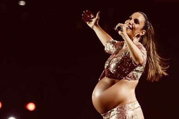 ivete aparece sorrindo usando roupa brilhante durante show