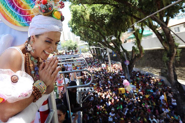 de turbante branco, carla perez acena para foliões 