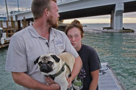 o casal aparece ao lado do cachorro após resgate