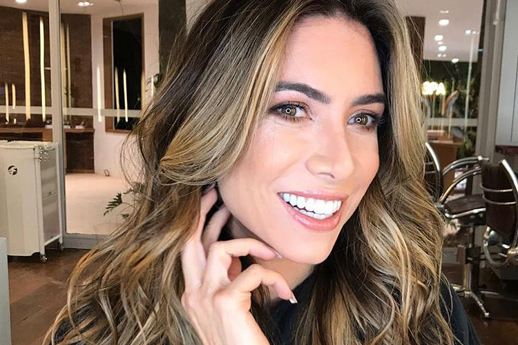 Patricia Abravanel posa sorridente em frente ao espelho 