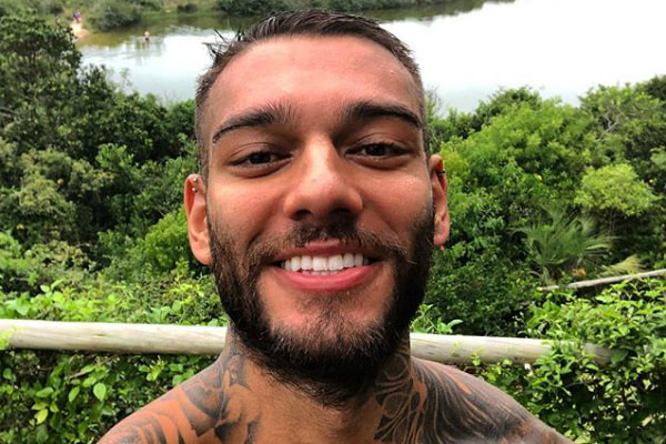 Sem camisa, Lucas Lucco sorri para foto e exibe dentes brilhantes