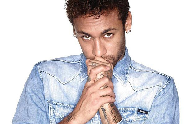 neymar usando uma camisa jeans com as mãos no rosto