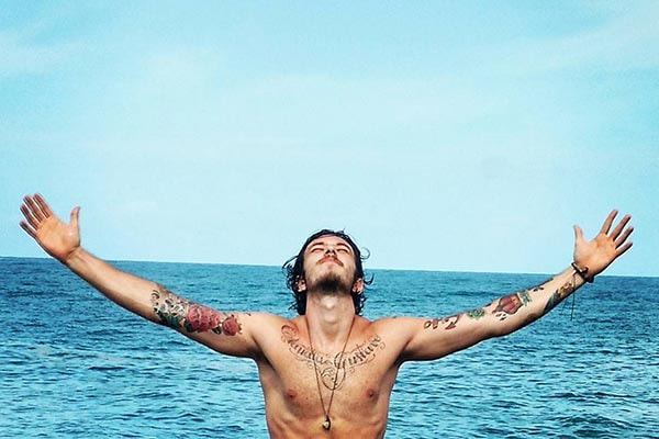 gabriel cartolano olhando para o céu com o mar ao fundo