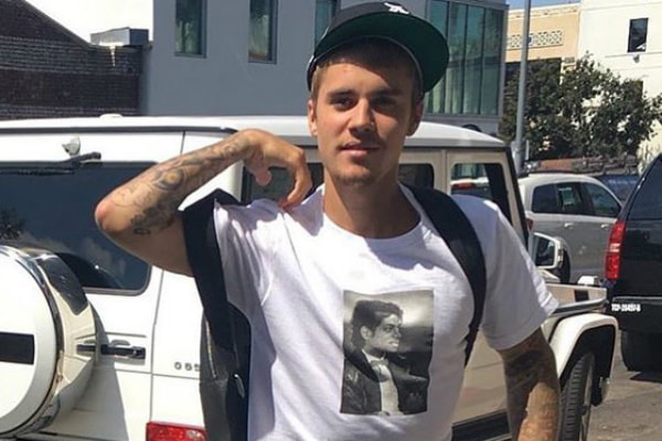 Justin Bieber passeia com mochila nas costas e camisa do Michael Jackson