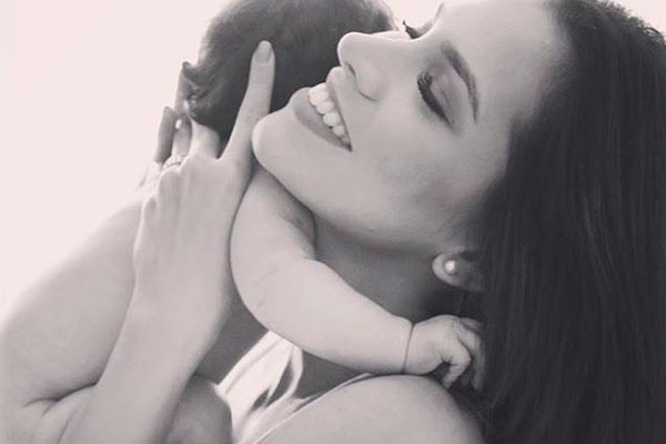 Adriana aparece segurando a filha, Linda