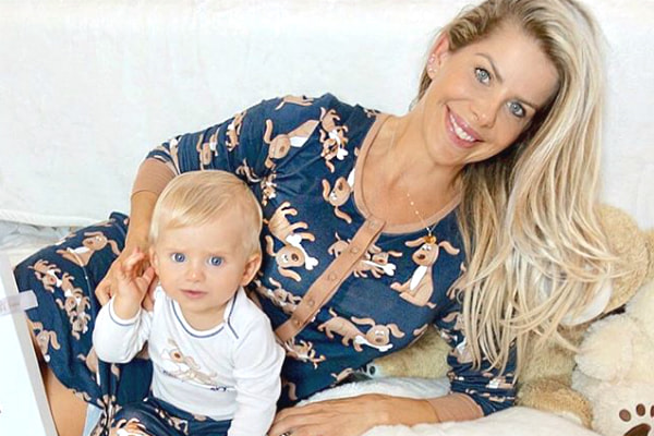 Com um vestido de cachorrinhos, Karina Bacchi aparece deitada ao lado do filho, Enrico