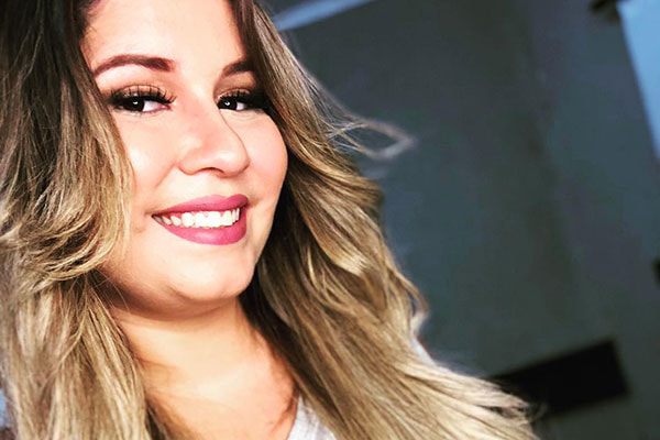 Marília Mendonça com os cabelos soltos sorrindo