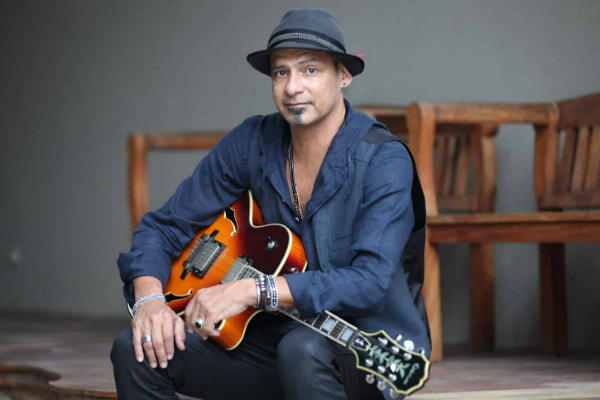 Cláudio Zoli posa para foto com violão no colo