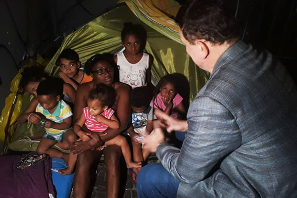 Cabrini conversa com mãe e seus filhos em uma barraca no centro de São Paulo