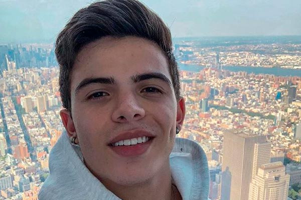 Thomaz Costa posta sorridente em foto 