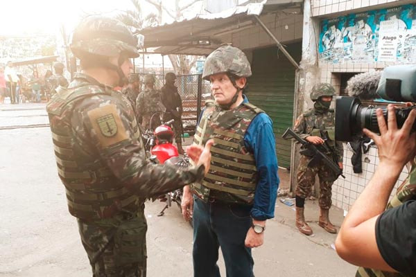 Com roupa do Exército, Roberto Cabrini conversa com soldado