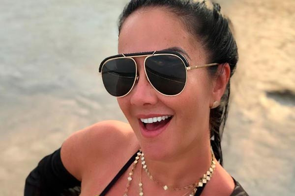 Helen Ganzarolli aparece sorridente na praia