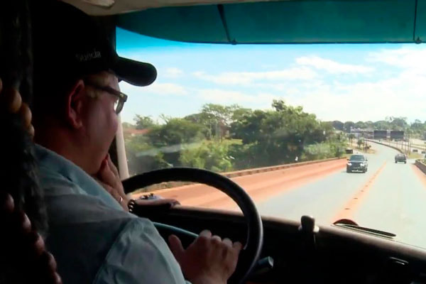 Caminhoneiro dirigindo em estrada