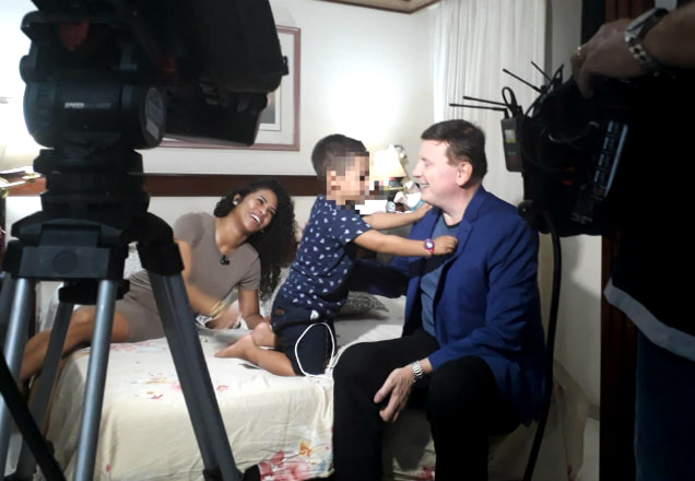 Roberto Cabrini brinca com filho de garota de programa enquanto mãe relata as dificuldades do dia a dia