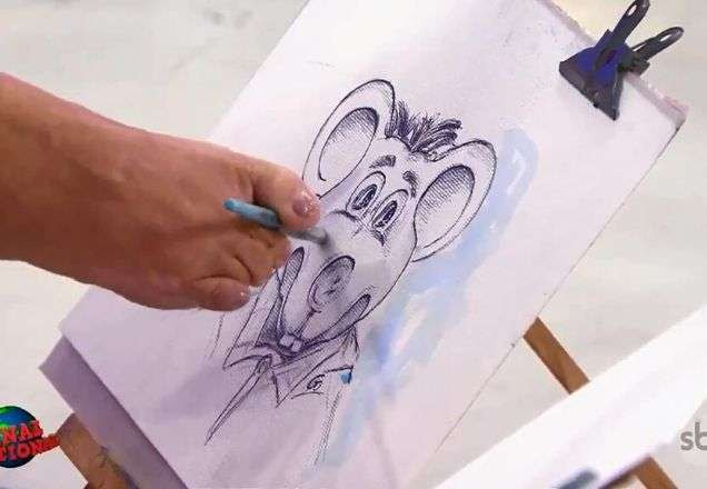 Artista pinta o rosto de Xaropinho com os pés