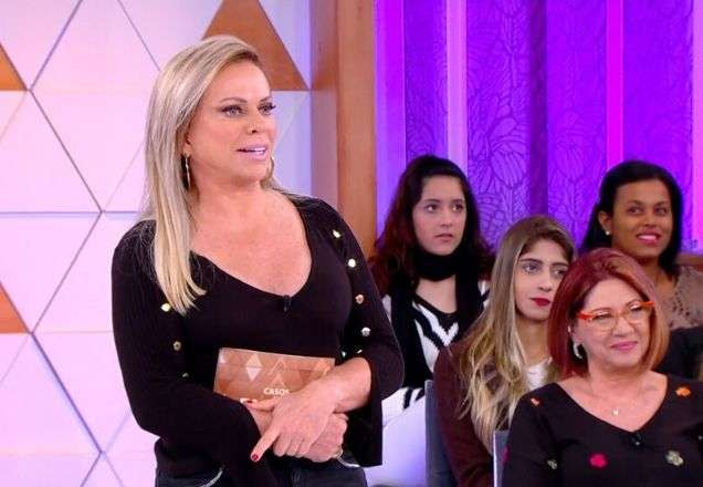 Christina Rocha usa uma camisa preta enquanto vê a marca da mordida | Foto: reprodução/SBT