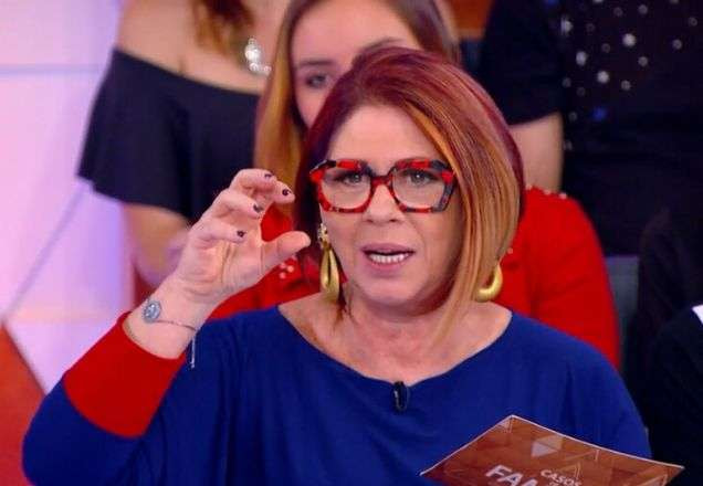 Anahy veste uma blusa azul e segura uma ficha enquanto usa um exemplo bem prático para explicar essa história | Foto: reprodução/SBT
