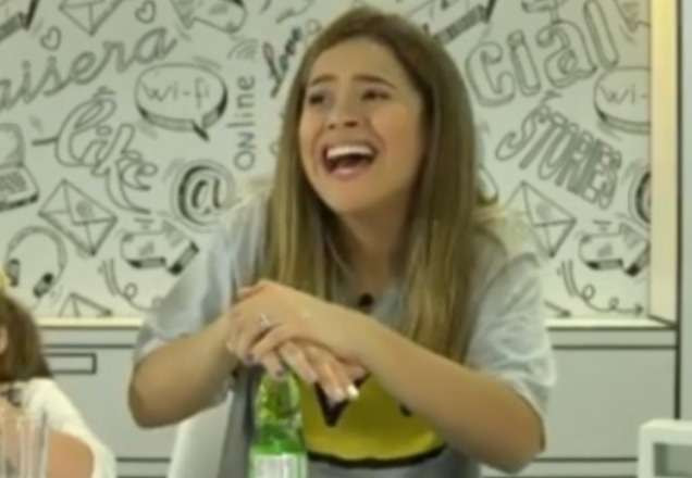 Maisa dá risada enquanto segura o pulso