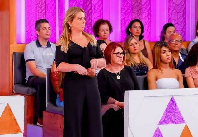 Christina Rocha usa uma roupa toda preta e olha preocupada para o palco | Foto: SBT