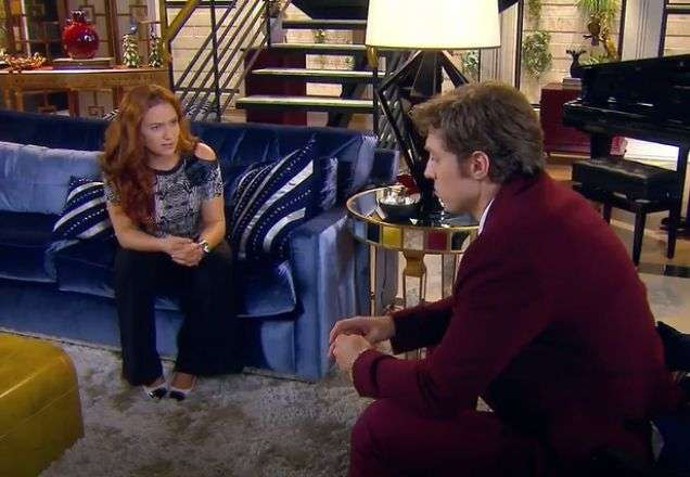 Regina e Geraldo conversando na sala da mansão
