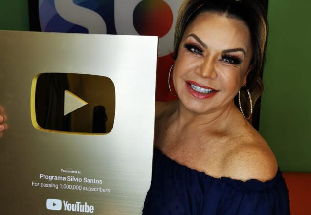 Flor segurando a placa de 1 milhão de Inscritos no YouTube