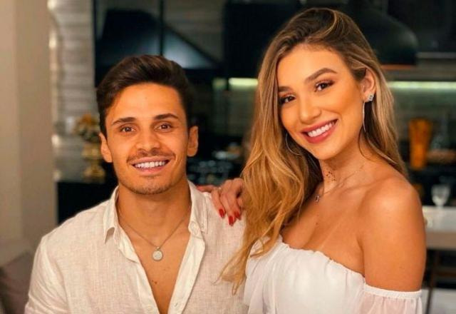 Bruna Santana e Raphael Veiga,  ambos sorrindo, com roupa branca de Ano Novo