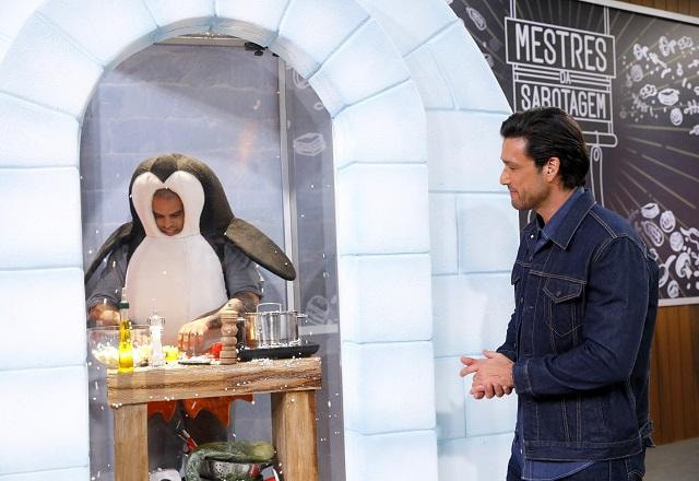 Sérgio Marone conversa com Diego, competidor que está vestido de pinguim dentro de um iglu
