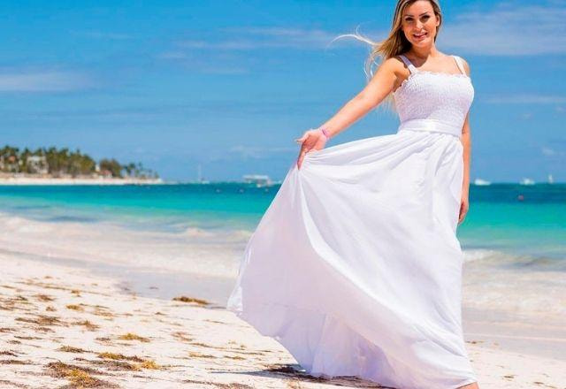 Andressa Urach de vestido branco, na areia da praia