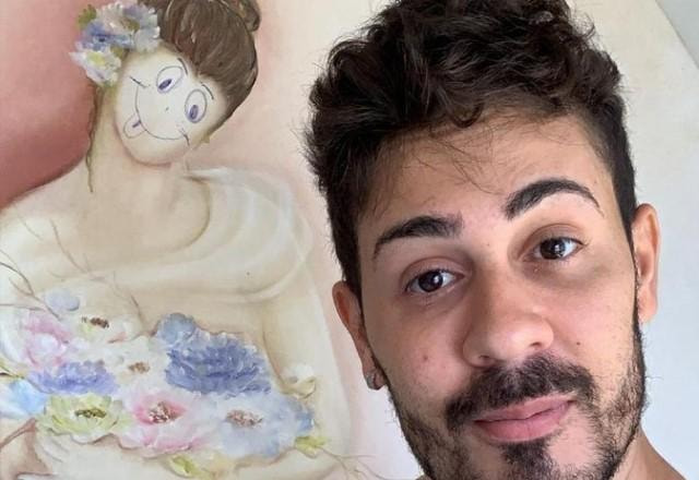 Carlinhos Maia ao lado de quadro rabiscado