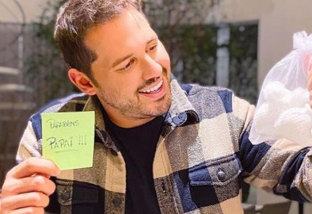 Dony de Nuccio segurando um bilhete escrito: Parabéns papai