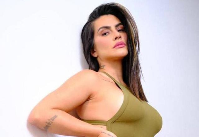 A atriz Cleo faz pose sensual usando blusa verde