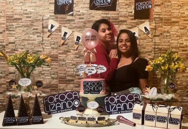 Verônica e uma amiga na mesa com o bolo de aniversário do Fofocalizando