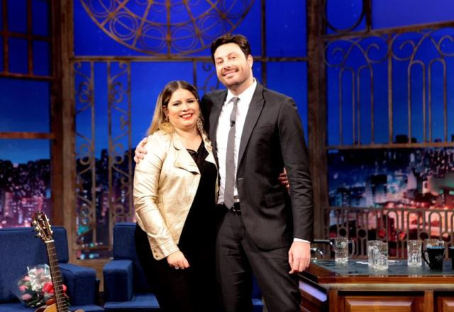 Marília Mendonça e Danilo Gentili posam para foto no palco.