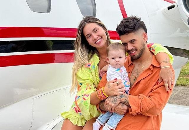 Virginia, Maria Alice e Zé Felipe sentados na asa de uma aeronave