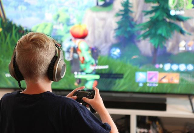 Foto de um adolescente jogando Fortnite no PlayStation 4