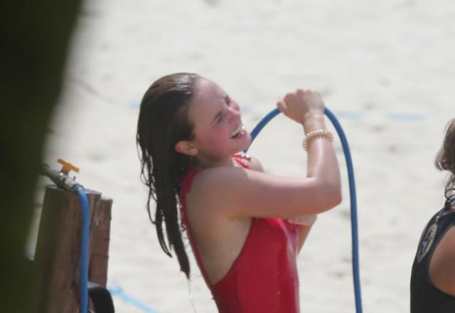 Larissa Manoela tomando banho de mangueira na praia.