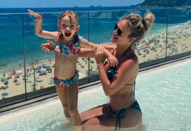 eliana e manu brincam em uma piscina
