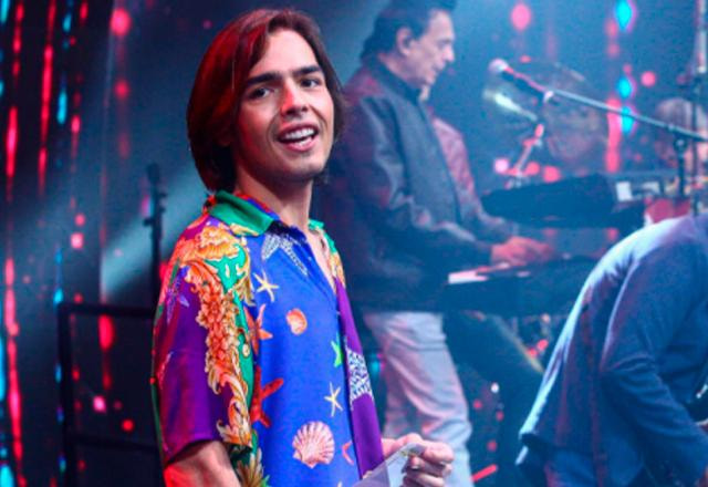 joão guilherme posa com roupa colorida no palco do programa de Fautão na TV