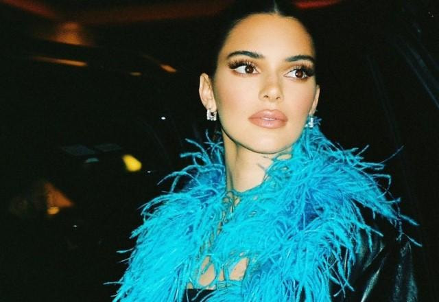 Kendall Jenner posa com jaqueta de couro e colar de plumas