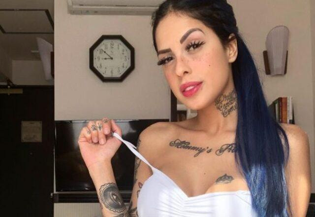 Tati Zaqui posa para foto segurando alça da blusa