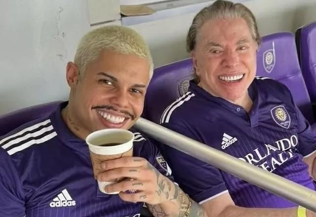 MC Lan e Silvio Santos posam para foto juntos em estádio.