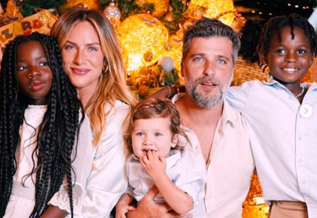 giovanna ewbank, bruno gagliasso e os três filhos dos atores na frente de uma árvore da natal