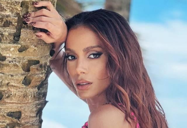 Anitta posa na praia perto de coqueiro