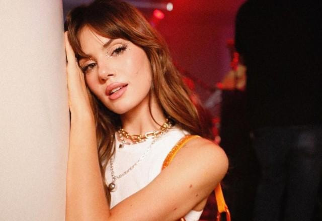 Camila Queiroz posa de roupa branca com a cabeça encostada na parede