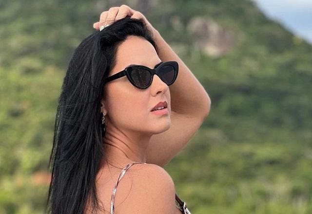 Graciele Lacerda posa de costas com a mão no cabelo