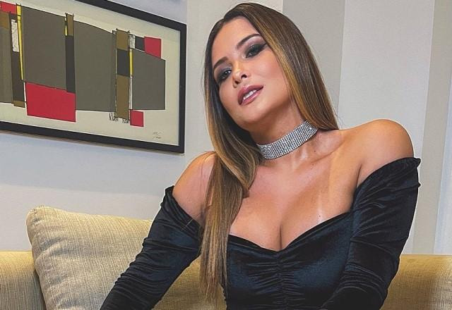 Geisy Arruda posa de vestido preto sentada no sofá