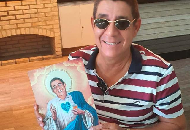 Zeca segura o próprio retrato onde ele aparece vestido de anjo