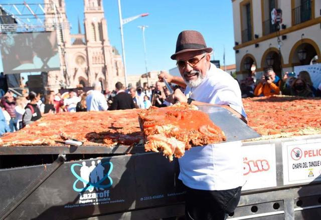 Argentino mostra uma fatia do maior bife à milanesa do mundo